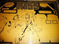 Image # 62115: KISS Partially Screened Backglass - Center 
(First the mirroring was applied, then the black. This clear glass is resting upon brown paper.)