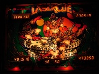 Image # 44345: Laser Cue Illuminated Defective Backglass 
(Words that should appear in the lit red areas at the bottom of the glass were mistakenly screened at the top of the glass, obscuring the game name. From the game with serial number 520 09500.)