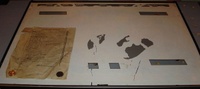 Image # 44347: Laser Cue Defective Backglass - Reverse 
(The final coat of paint (opaque silver) was screened with the backglass inverted. This placed the words 'Game Over', 'Highest Score', 'Shoot Again', 'Ball In Play', 'Match', and 'Tilt' at the top of the glass. From the game with serial number 520 09500. Included in this image is the 'inspection' form found inside the game.)