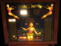 Image # 29183: Balls-A-Poppin Illuminated Backglass 
(Visible on each side of the lady's head are the reflections of the lamps positioned under the apron. Serial number B1710.)
