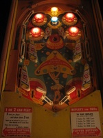 Image # 29185: Balls-A-Poppin Pop Bumpers Lit 
(Hitting the yellow bumper lites the pop bumpers for increased value, turns off the slingshot kicker lights, and turns on lamps under the apron to illuminate the flipper area. Serial number B1710.)