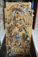 Image # 73483: Mousin' Around! Under Playfield 
(The Trap (Ball Eater) Assembly seen in the lower left corner of this playfield (as viewed in this image, and is partly blue in color) has a metal bracket holding it to the playfield. Reportedly, this bracket was added after-factory to improve stability. See the close-up image in this listing.)