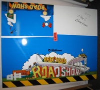 Image # 66996: Red & Ted's Road Show Preliminary Color Test 
(Laminate on wood. The wood would first get a white vinyl laminated to it for printing purposes. A marker was used on letters 'ROA' to test a yellow color rather than white. The orange stripes and yellow letters were ultimately rejected by company management.)