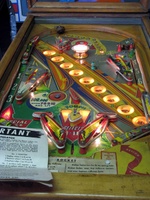 Image # 52399: Rocket Illuminated Playfield 
(The triangular post between the flippers is not original, and would be round. The red flipper above this post is not original and we do not know if it operates. The posts in the lower left and right corners of the playfield have been moved from their original positions.)