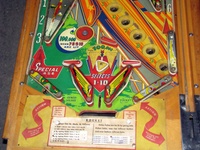 Image # 52402: Rocket Lower Playfield 
(The triangular post between the flippers is not original, and would be round. The red flipper above this post is not original and we do not know if it operates. The posts in the lower left and right corners of the playfield have been moved from their original positions.)