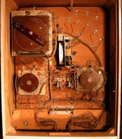 Image # 64749: World Champ Inside Backbox 
(A round hole in the insert can barely be seen just below the M-relay that is below the replay wheel. This hole was intended for a lamp for 'Game Over' Illumination but the socket was not wired in the production run. A bell is missing from the 0-9 unit on this particular game. The brown eyelet screw above the replay unit is not original to this game.)