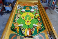 Image # 63510: Hits and Runs Playfield 
(The left-side ballplayer figurine is not original to this game and has been repainted as well. The pop bumper caps and the flippers have been touched up with blue ink. The elevated screws below the flippers are not original to this game. Serial number A1283.)