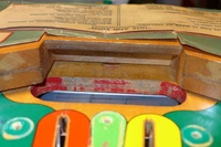 Image # 63518: Hits and Runs Outhole Trough And Serial Number 
(The serial number A1283 is stamped on the playfield.)