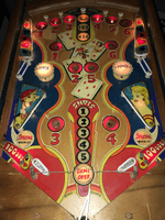 Image # 75422: Canasta Illuminated Playfield 
(This playfield is missing the two flipper-shaped posts at the very top center of the playfield, above the white post, and where a rubber ring fits around all three of them.)