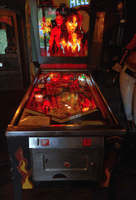 Image # 82770: Hell Illuminated Front View 
(This game contained no LEDs but an illumination problem caused some backglass bulbs to shine too brightly for this picture, causing halos on the woman.)