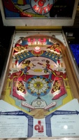 Image # 67916: Dyn O' Mite Illuminated Playfield - Glass On 
(The bumper cap and apron cards are reproduction. The flippers are a later version from this manufacturer where screw heads and washers are not visible. Decals were added to simulate the original flippers.)
