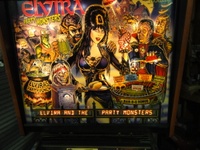 Image # 50878: Elvira and the Party Monsters Illuminated Backglass with Modesty Decal 
(The decal is included with the game to be applied by the operator if desired.)