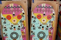Image # 49332: Flip a Card Two Playfield Color Versions 
(The left playfield has a light beige color, while the right playfield has white, on the top 'K' rollovers worth 300 points, in the lower pop bumper circle, and in the playfield arrows that point to the targets.)