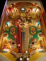 Image # 31094: Flipper Clown Sample Game - Illuminated Playfield 
(Center red and white roto-target lights are identified differently here than on production games. Serial number '01004 S' is stamped on outside of cabinet above the coin door.)