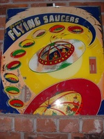 Image # 7870: Flying Saucers Backglass 
(The rectangular window on the right side of the backglass allows the player to view a pendulum tilt.)